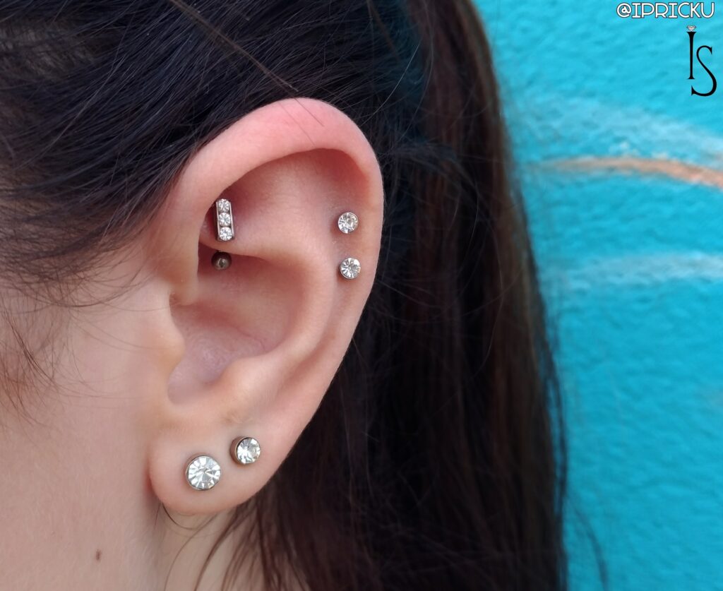 Rook piercing featuring a channel-set curved barbell with clear Swarovski CZ gemstones from Industrial Strength, showcasing elegant design and precise placement.