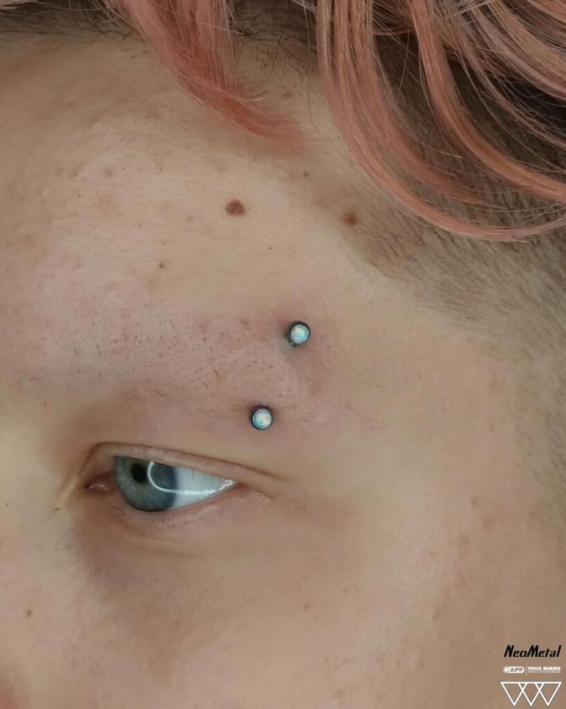 Fresh eyebrow piercing featuring a white opal curved barbell from NeoMetal, highlighting the opalescent shimmer and precise placement on the brow.