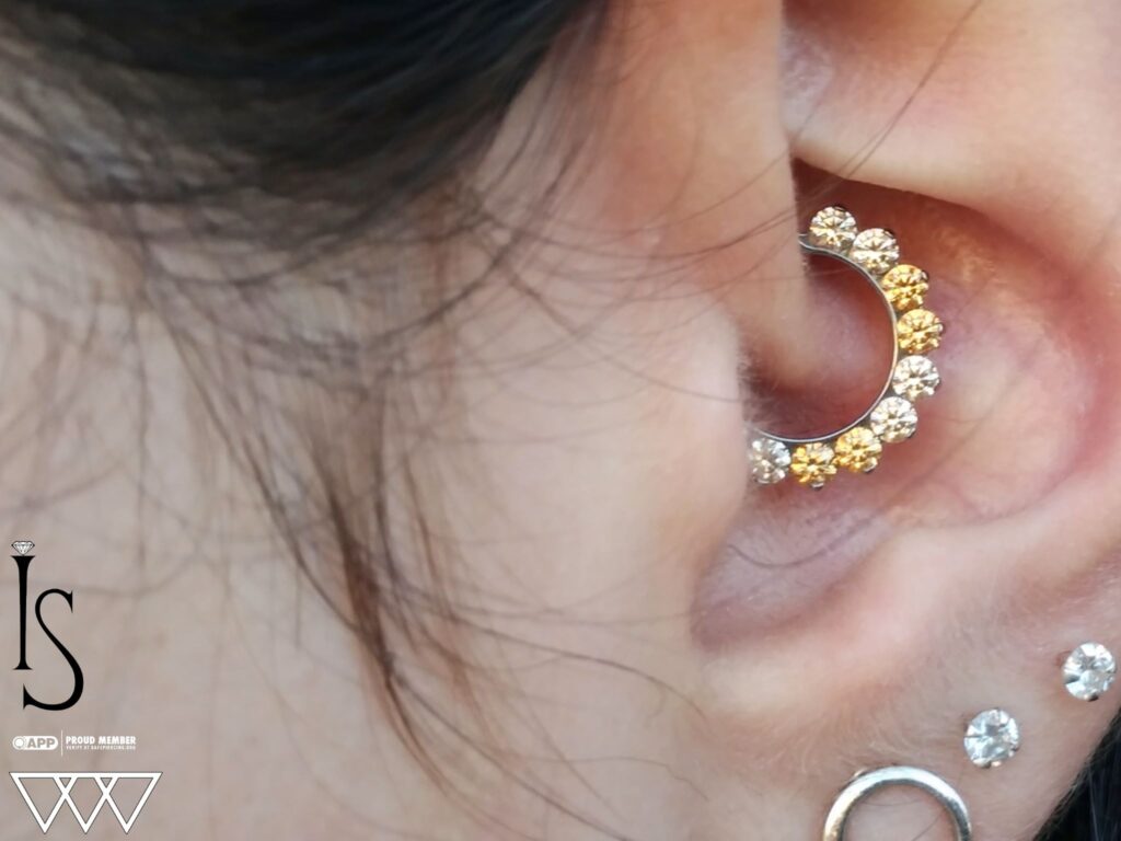 Daith Piercing in Staten Island, NYC | Professional Piercing Close-up of a healed daith piercing adorned with an "Odyssey" septum clicker from Industrial Strength, showcasing the intricate design and precise placement within the ear's innermost cartilage fold.