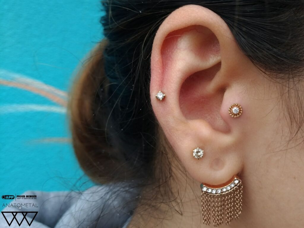 Tragus piercing featuring an 18k rose gold “Virtue” end from Anatometal, set with a genuine Swarovski gemstone, highlighting elegant design and precise placement.