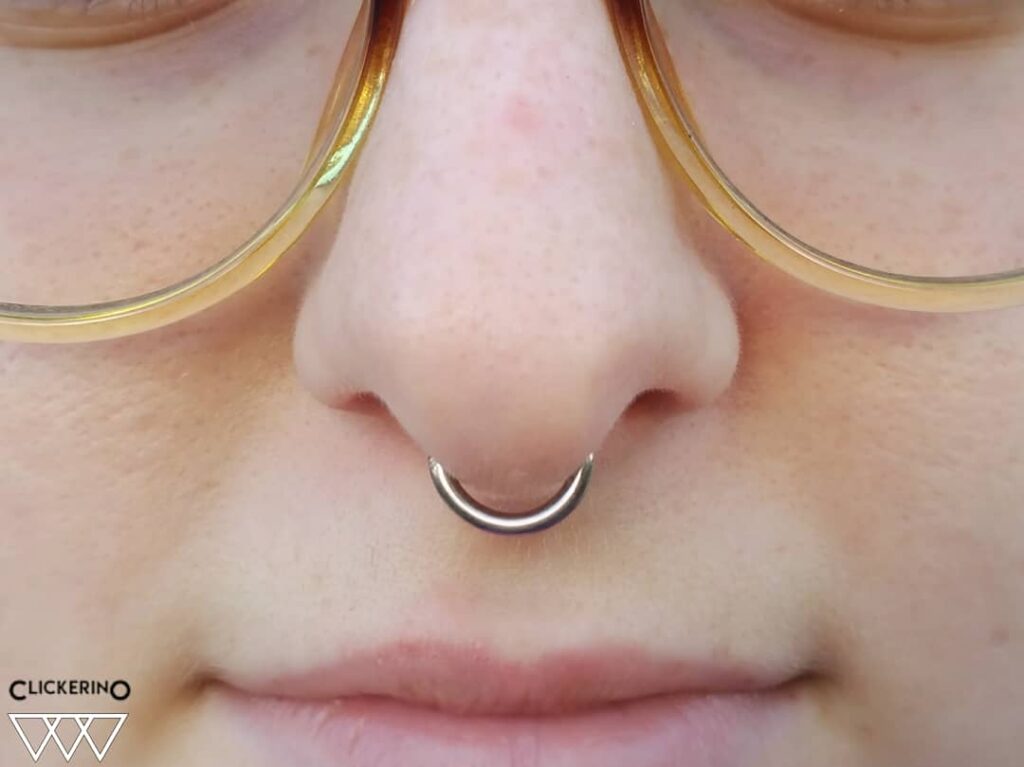 A healed septum piercing featuring a titanium clicker hoop from Clickerino, offering a sleek, seamless design that complements the nose’s central anatomy.