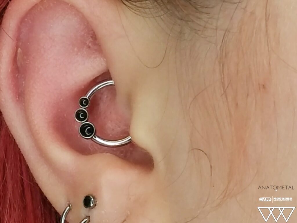 Piercing Studio for Spotswood & East Brunswick – Clean, Private Experience A daith piercing featuring a forward-facing captive ring with a bezel-set black onyx arc cluster from Anatometal, offering a versatile and stylish look with interchangeable components.