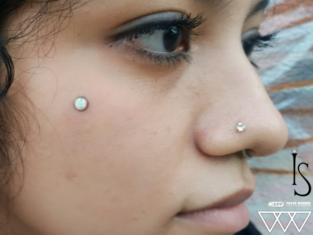 Surface Anchors in Staten Island, NYC | Professional Piercing A microdermal surface anchor featuring a bezel-set white opal from Industrial Strength, resembling a subtle opal freckle on the skin.