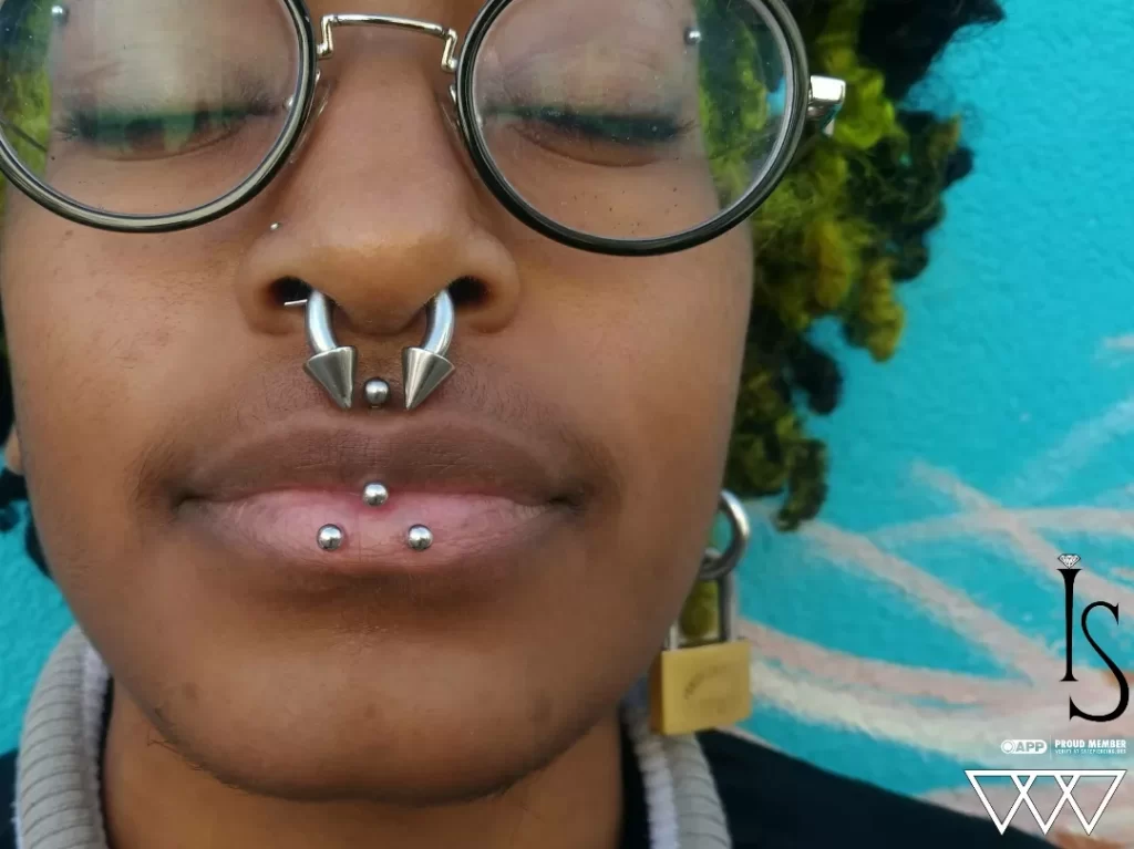 Oral Piercings in Staten Island, NYC | Professional Piercing Close-up of paired inverse vertical labret piercings featuring titanium curved barbells from Industrial Strength, showcasing symmetrical placement and polished finish.